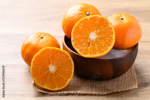 Mandarin orange fruit in wooden bowl on wooden background, Tropical fruit