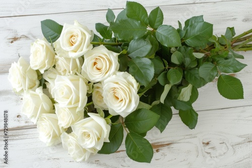 A bouquet of white roses on white wooden background