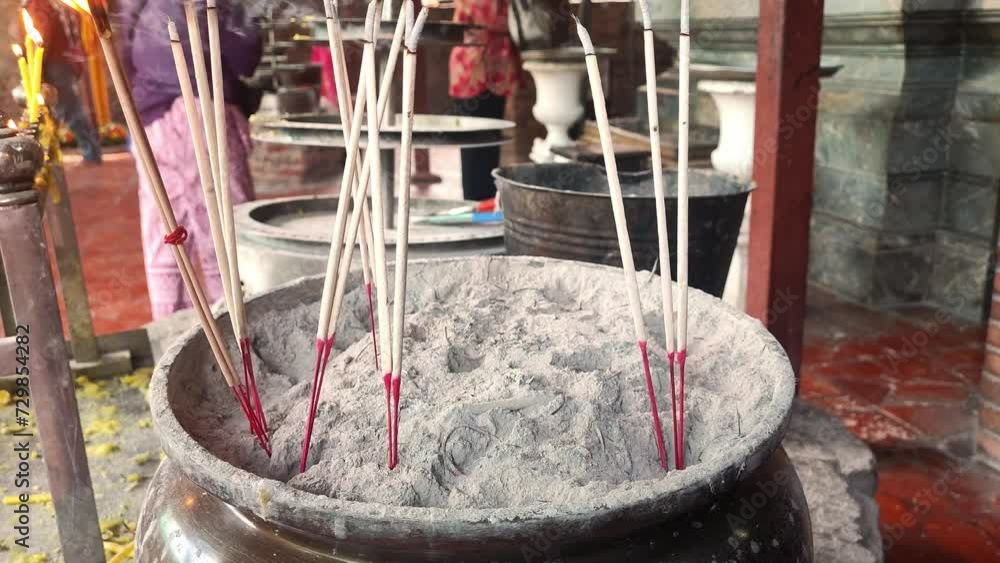 Place incense sticks into the incense burner, Incense burners. Incense sticks. Incenses or joss sticks in temple. 