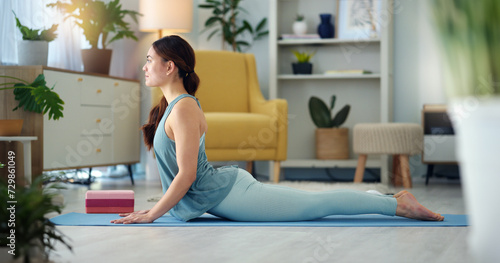 Exercise woman, yoga stretching and home fitness in living room floor for wellness, balance training and strong body. Healthy lady, pilates focus and flexible cobra workout training in house lounge