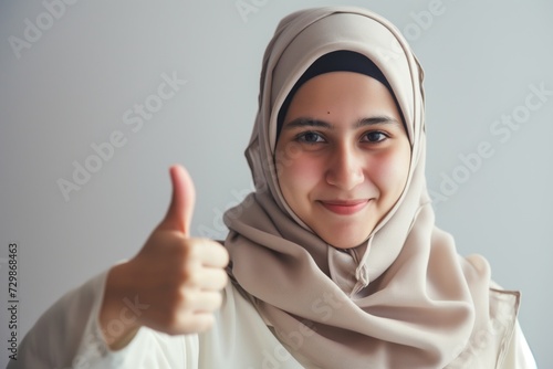 woman wearing hijab giving a thumbsup after a successful exam