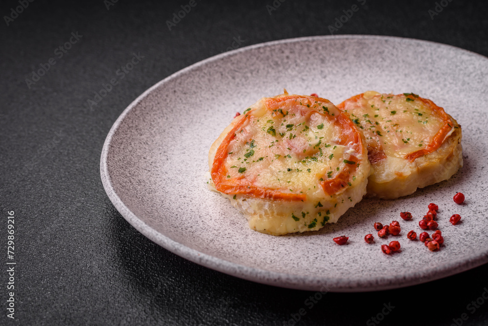 Delicious baked fish fillet with cheese, tomatoes, salt, spices and herbs