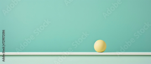Perfectly balanced yellow sphere on minimal shelf against green background © Breezze
