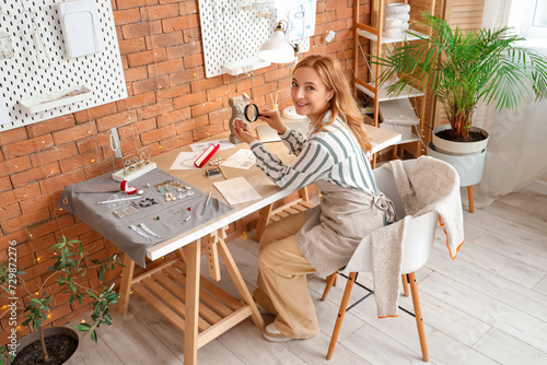 Female jeweler examining br...