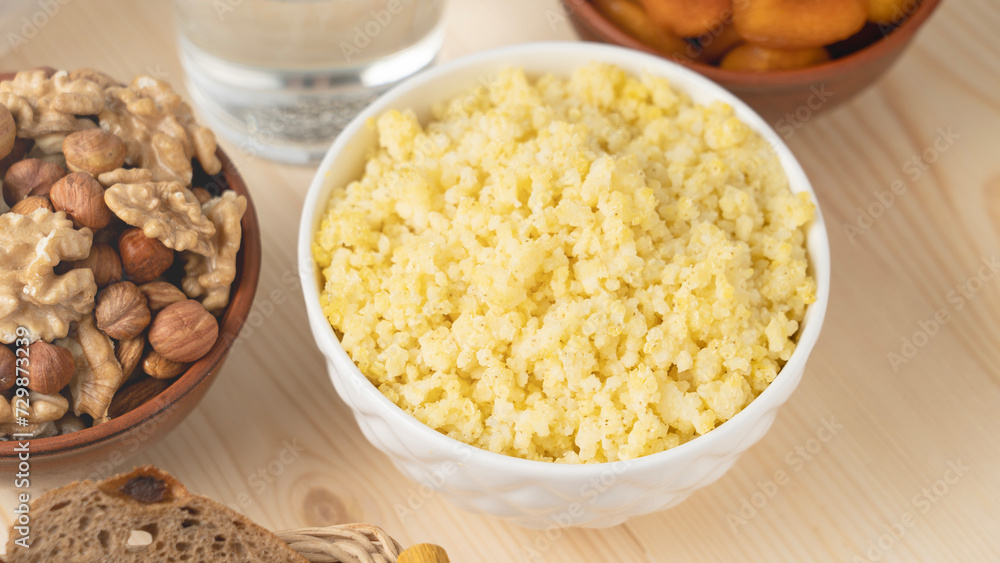 A dish of healthy cereals - millet porridge in a clay bowl. Selective focus, millet porridge in a cup A dish of healthy cereals - millet porridge in a clay bowl. Selective focus, millet porridge in a cup