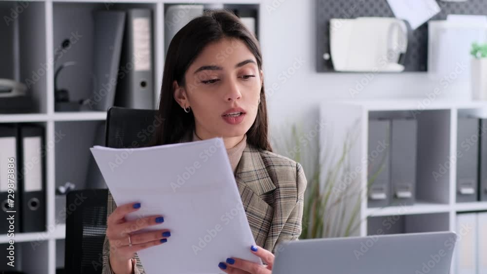 Woman entrepreneur working in modern office, talking during video call using laptop, making paperwork, accounting business, remote communication. Woman entrepreneur working in modern office, talking during video call using laptop, making paperwork, accounting business, remote communication.