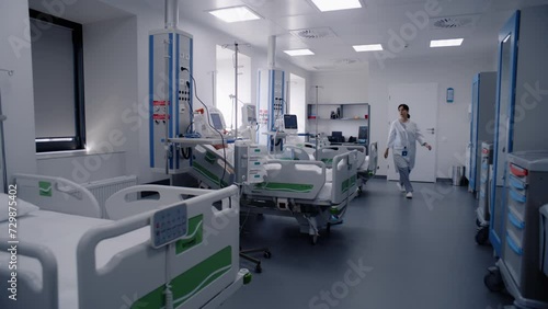 Emergency room with modern equipment in hospital. Elderly man in oxygen mask sleeps in bed after successful surgery. Nurse takes care of old patient. Intensive care department in medical facility.