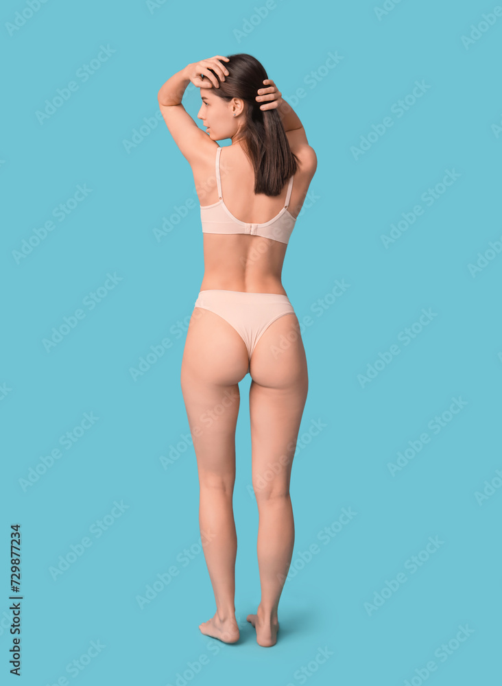 Beautiful young woman in underwear on blue background Beautiful young woman in underwear on blue background