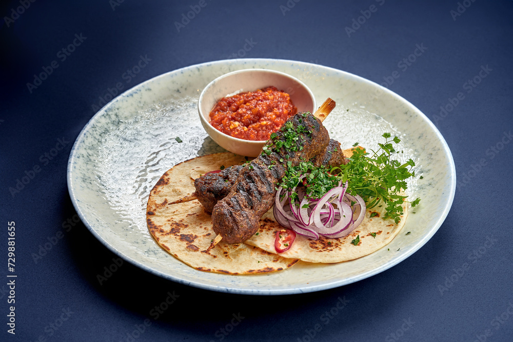 Turkish Lula kebab with pita bread and sauce in a plate Turkish Lula kebab with pita bread and sauce in a plate