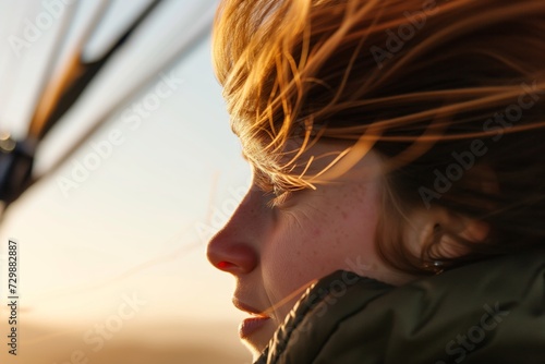 closeup of a balloonists face, wind gently blowing hair, eyes on horizon