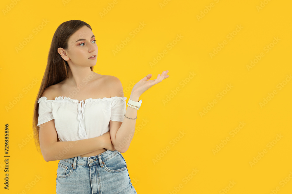 Attractive young girl stands on a yellow background Attractive young girl stands on a yellow background