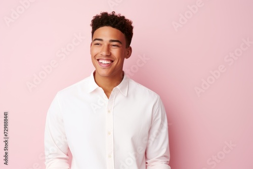 Portrait of a happy young african american man smiling against pink background © Inigo