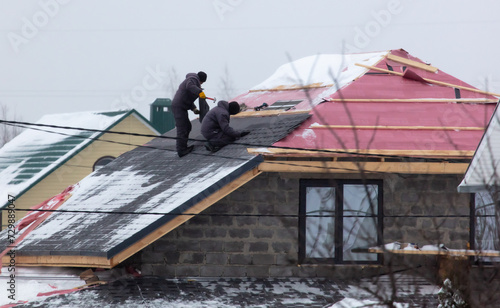 Wallpaper Mural Workers install tiles on the roof of a house in winter Torontodigital.ca