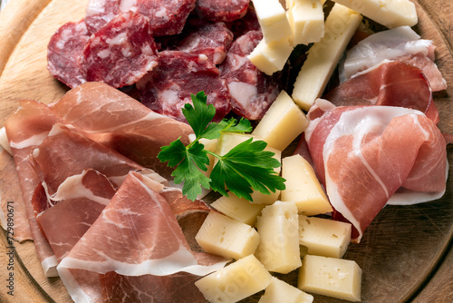 Tagliere con delizioso prosciutto crudo, pecorino e salame, alimenti tipici della gastronomia italiana, cibo europeo  photo