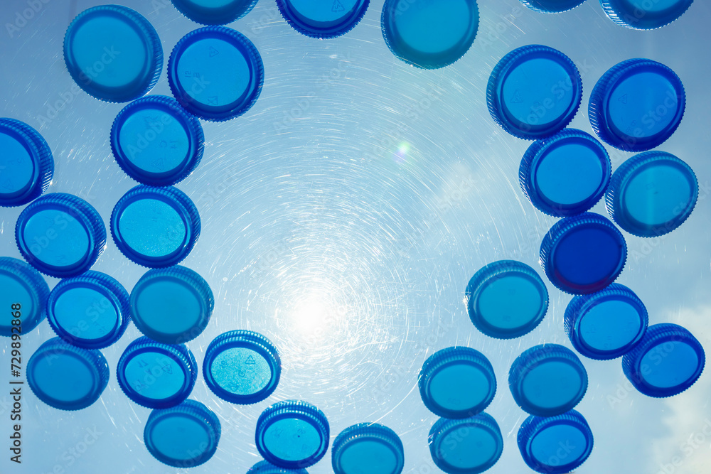 plastic lids or drinking water bottle caps for recycling on the glass. washing and drying water bottle caps. waste management and recycling to Plastic packaging manufacturer plastic lids or drinking water bottle caps for recycling on the glass. washing and drying water bottle caps. waste management and recycling to Plastic packaging manufacturer