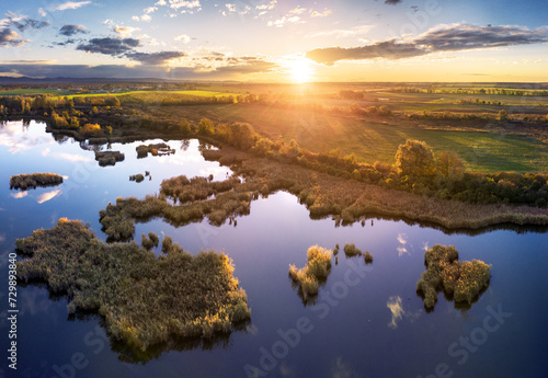 Forest Lake at sunset. Wild Lake in swamp, drone view. Rural landscape with lakes. Forest at bog.