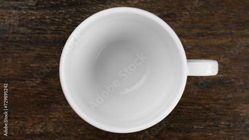 White cup on wooden board, top view
