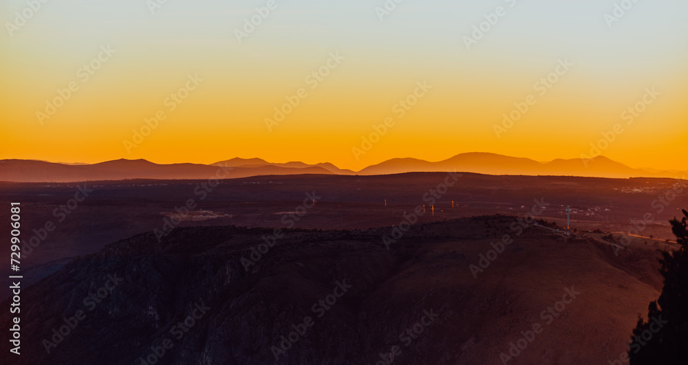 Capturing the breathtaking beauty of a vibrant orange and purple sunset over a majestic mountain during a serene summer evening Capturing the breathtaking beauty of a vibrant orange and purple sunset over a majestic mountain during a serene summer evening