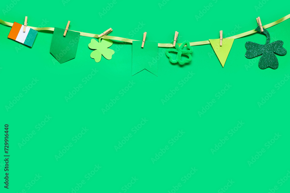 Paper garland with clover and Irish flag for St. Patrick's Day celebration on green background Paper garland with clover and Irish flag for St. Patrick's Day celebration on green background
