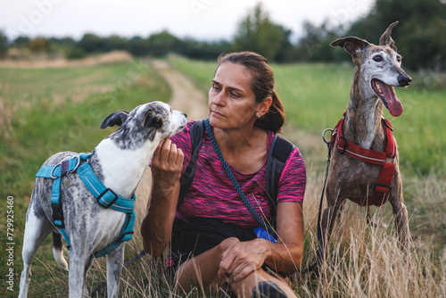 Photography Woman resting with her dogs during dog walking outdoors