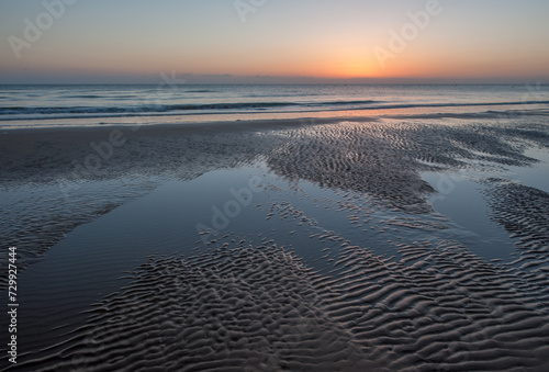 Sunrise with low clouds on Omaha Beach Normandy France