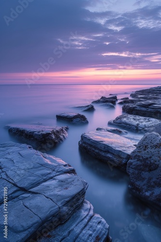 Soft, pastel hues reflecting off a tranquil seascape during twilight.