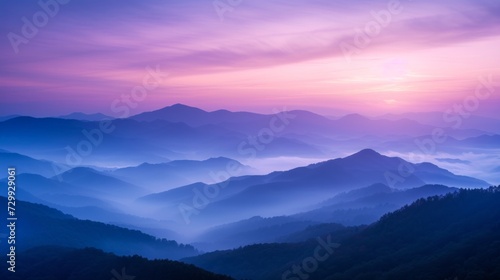 Mountain Mist at Dawn: Shades of purple and blue shrouded in mist evoke the majesty of mountains at sunrise. © olegganko