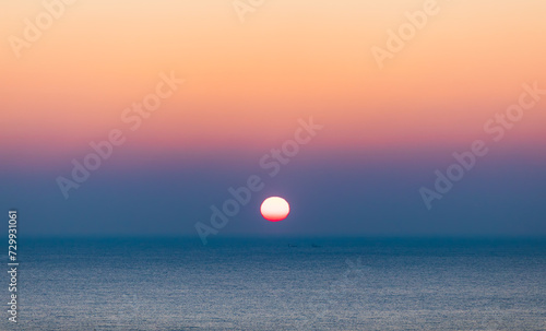 Fototapeta Naklejka Na Ścianę i Meble -  Sea sunrise landscape. Sunlight reflecting on the sea surface and a ship passing between it