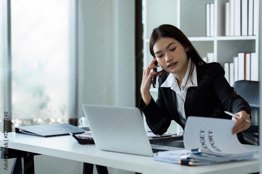Businesswoman on the phone and using laptop at office. Businesswoman professional talking on mobile phone Businesswoman on the phone and using laptop at office. Businesswoman professional talking on mobile phone