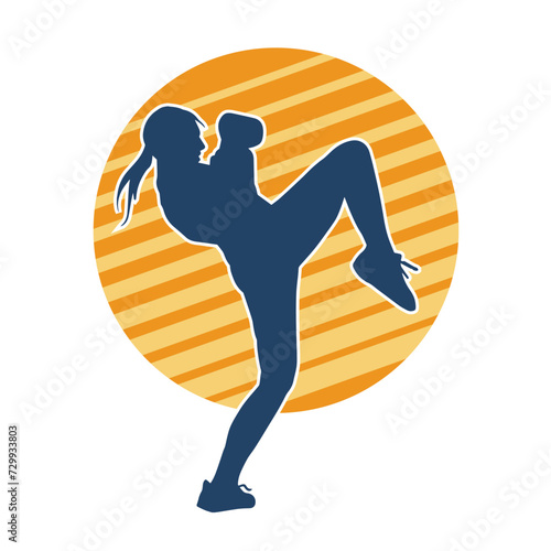 Silhouette of a female kickboxer athlete in action pose. Silhouette of a sporty woman doing kicking pose.