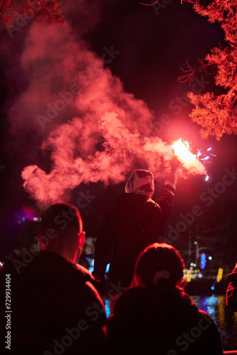 Man holding red torch with smoke to celebrate