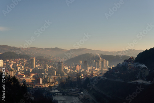 View of the city of Uzice, Serbia from fortrees above the city with sun over the buildings