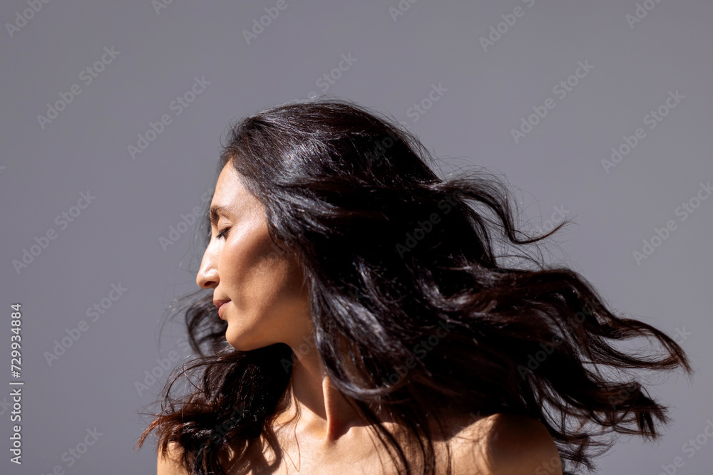 A studio fashion shot of a young attractive woman with beautiful wavy hair and perfect skin. A studio fashion shot of a young attractive woman with beautiful wavy hair and perfect skin.