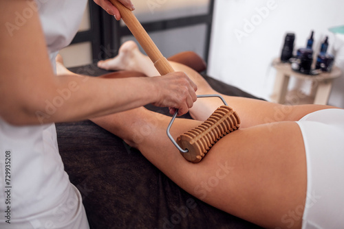 Massage madera. Maderotherapy anti cellulite massage treatment with wooden prop photo