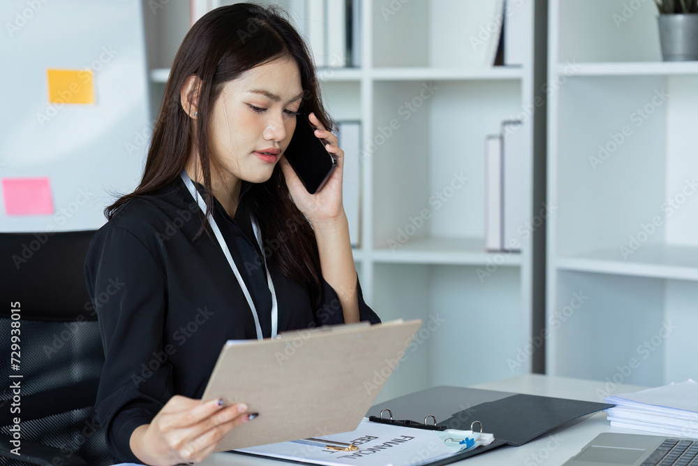 Businesswoman on the phone and using laptop at office. Businesswoman professional talking on mobile phone Businesswoman on the phone and using laptop at office. Businesswoman professional talking on mobile phone