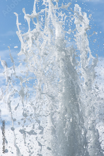 jet of water with splashes on a blue background.