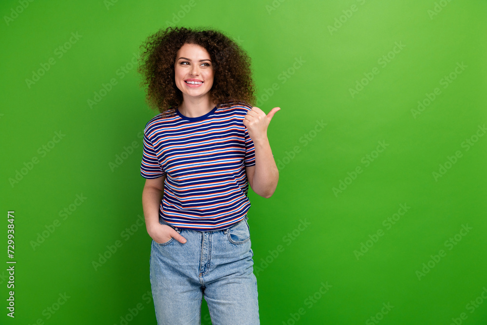 Portrait of lovely positive person look direct thumb finger empty space offer isolated on green color background Portrait of lovely positive person look direct thumb finger empty space offer isolated on green color background