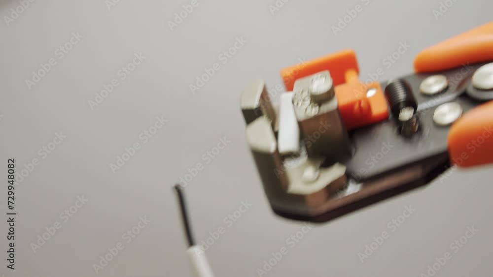 Electrician strips wire with wire stripper
Electrician strips wire with wire stripper