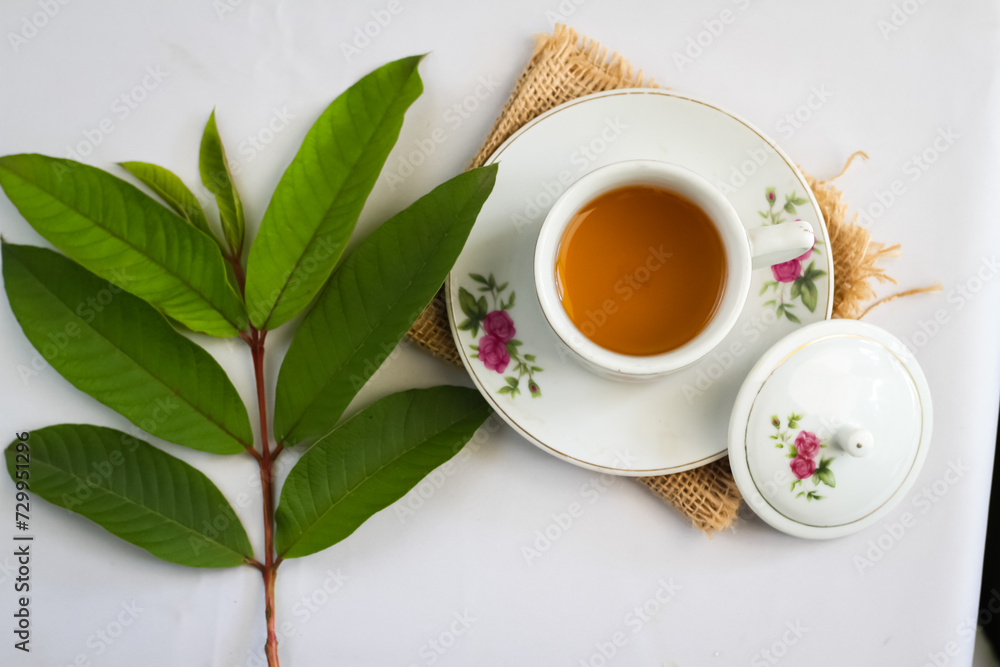 Guava leaf tea in a white cup isolated on White background, herbal drink for diarrhea and cholesterol.selective focus. flat lay angle. Guava leaf tea in a white cup isolated on White background, herbal drink for diarrhea and cholesterol.selective focus. flat lay angle.