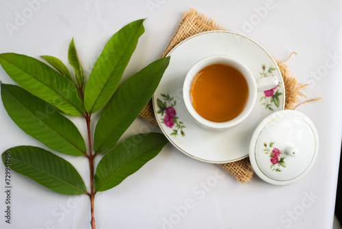 Guava leaf tea in a white cup isolated on White background, herbal drink for diarrhea and cholesterol.selective focus. flat lay angle.