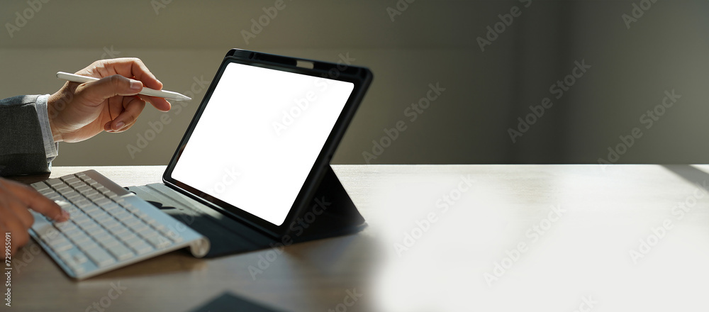 Businessman working using tablet from home office with blank screen for design mockup Businessman working using tablet from home office with blank screen for design mockup