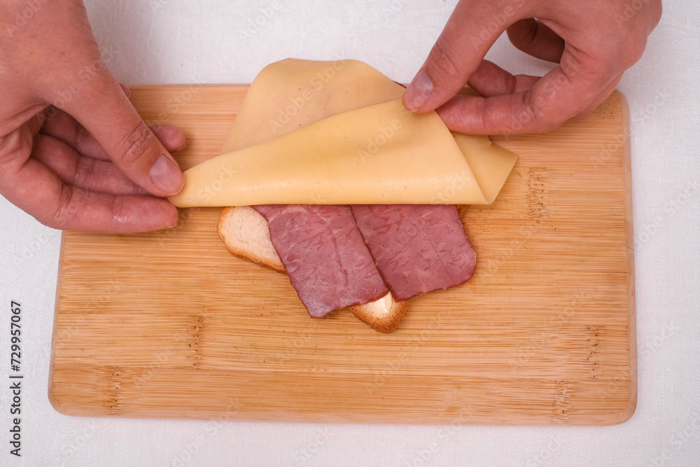 woman preparing toast with cheese and ham