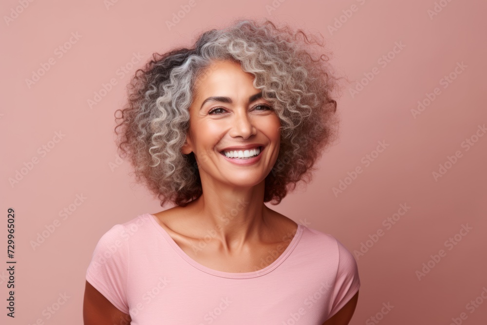 Portrait of a beautiful middle-aged woman with grey hair on a pink background Portrait of a beautiful middle-aged woman with grey hair on a pink background