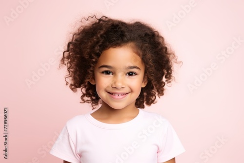 Portrait of a cute little african american girl with curly hair on a pink background © Inigo