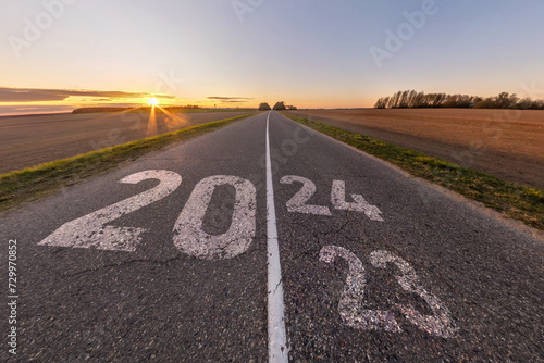 sign 2023, 2024 and start on asphalt road highway with sunrise or sunset sky background. concept of destination in future, freedom, work start, run, planning, challenge, target, new year