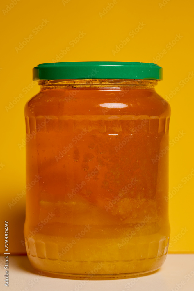 Jar of natural honey made at home on a table. Jar of natural honey made at home on a table.
