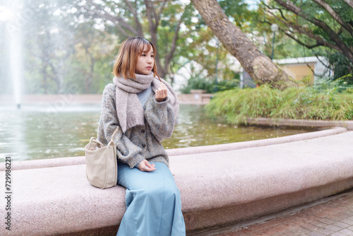 冬の寒い香港尖沙咀の公園で過ごす20代の中国人女性 A Chinese woman in her 20s spending time in a park in Tsim Sha Tsui, Hong Kong, which is cold in winter photo