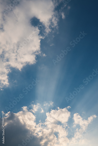 Sky and clouds natural background with sun rays shining from behind the clouds