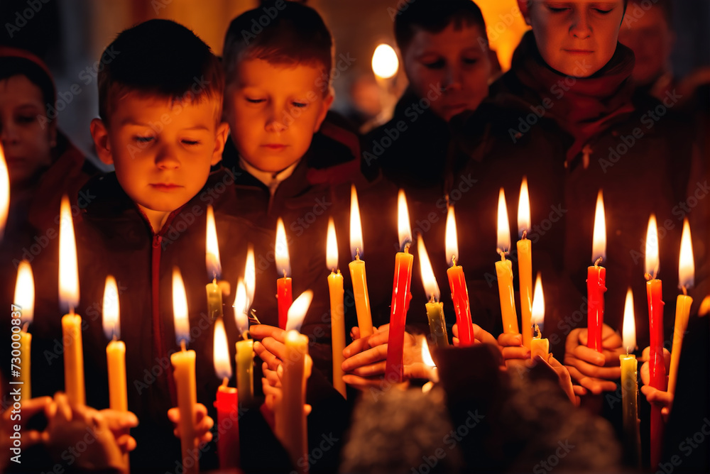 A group of adults and children light candles and pray in the church A group of adults and children light candles and pray in the church