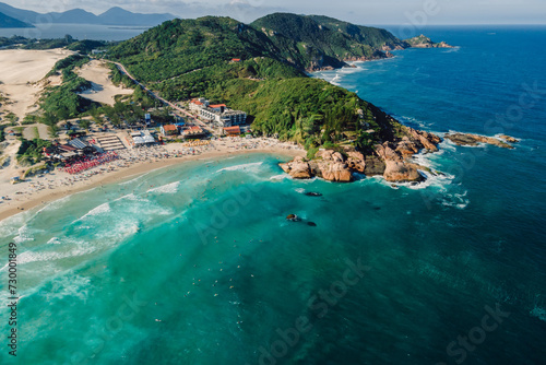 Popular holiday beach with cape and ocean with waves in Brazil. Aerial view